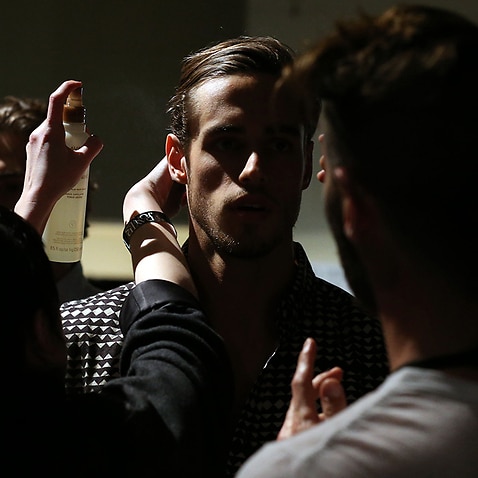 A model and hairdresser prepare for a rehearsal 