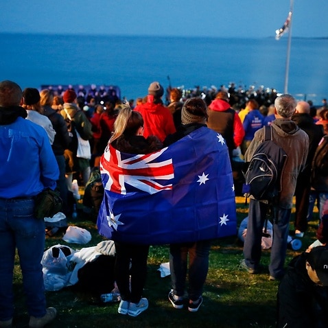 A pair draped with an Australian flag, participate in the Dawn Service ceremony at the Anzac Cove beach