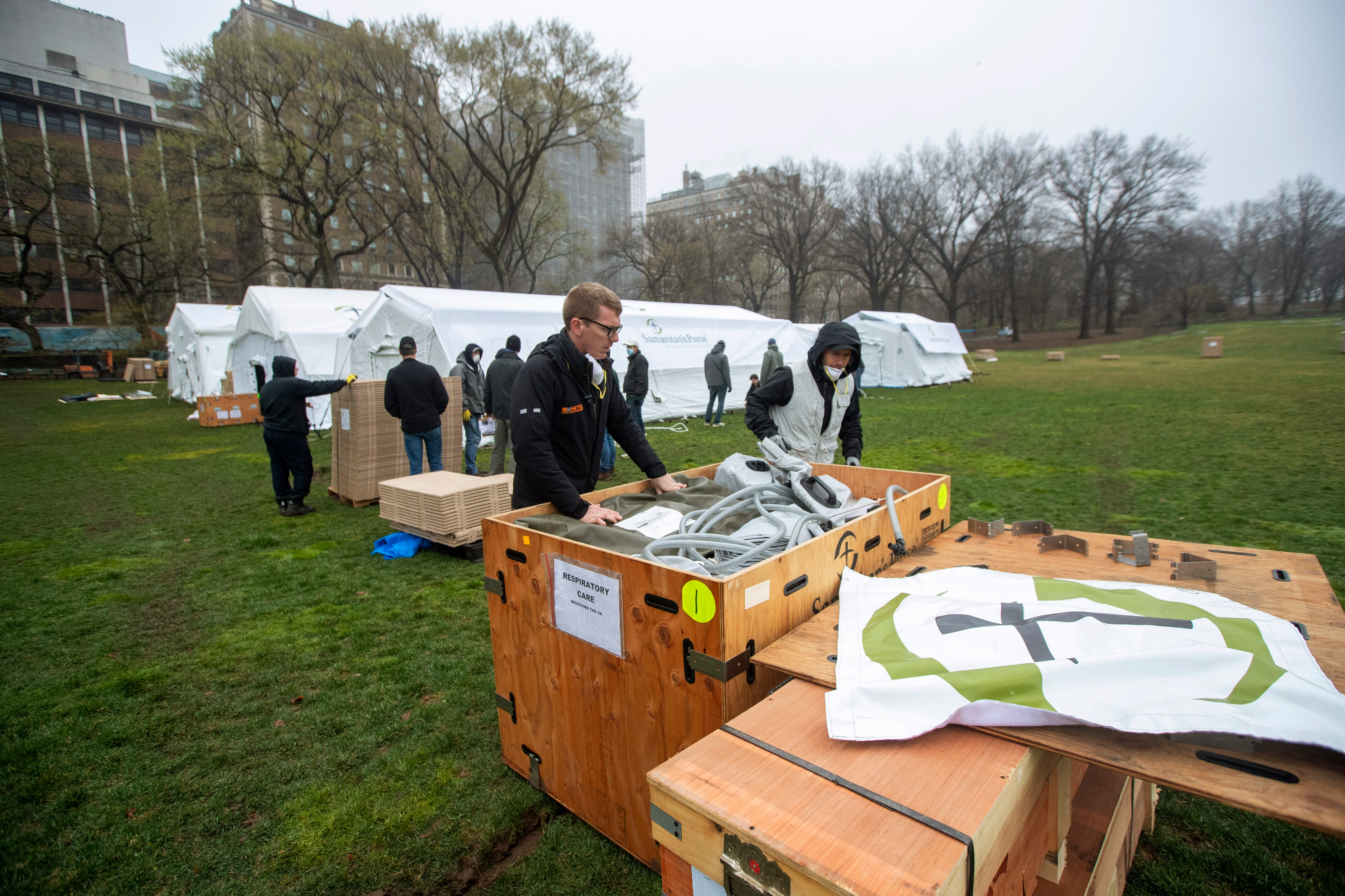 A Samaritan's Purse crew works on building an emergency field hospital equipped with a respiratory unit in New York's Central Park across from the Mount Sinai Hospital, Sunday, March 29, 2020. (AP Photo/Mary Altaffer)