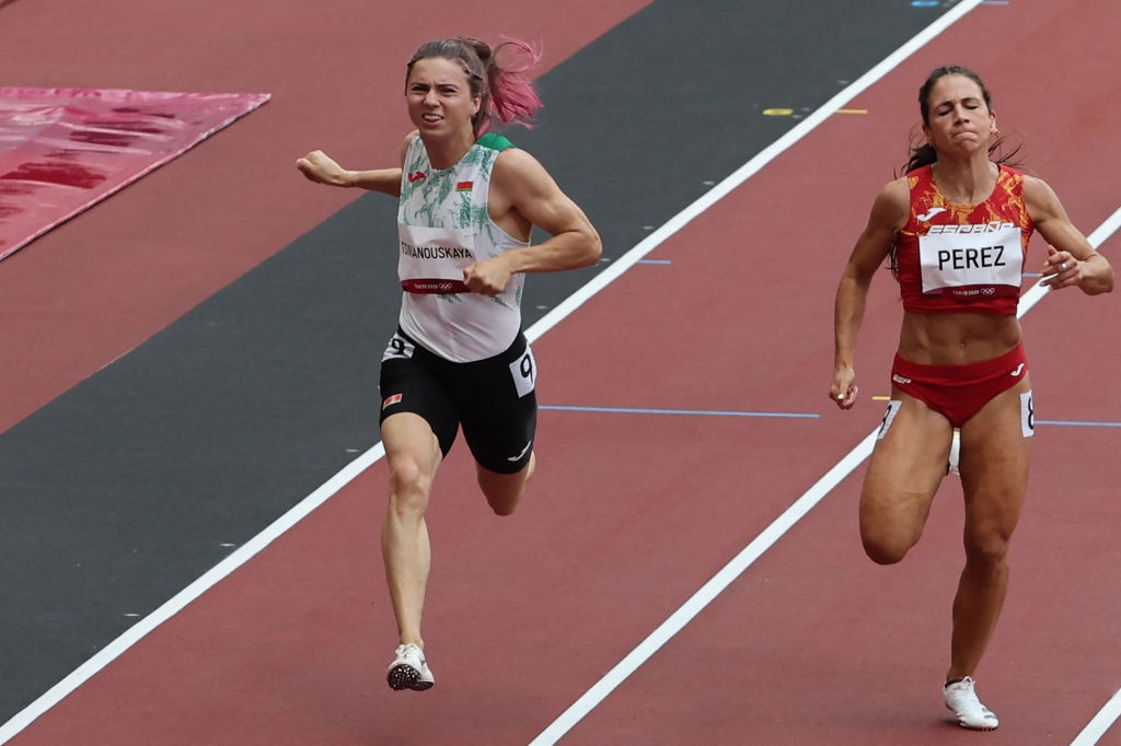 Belarus' Krystsina Tsimanouskaya (L) and Spain's Maria Isabel Perez competing in the women's 100m heats during the Tokyo 2020 Olympic Games.