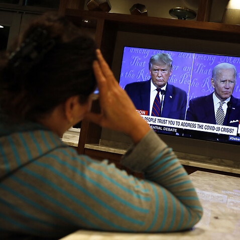 A woman watches on TV first 2020 presidential campaign debate between U.S. President Donald Trump and Democratic presidential nominee Joe Biden, in Washington on September 29, 2020. Photo by Yuri Gripas/ABACAPRESS.COM.