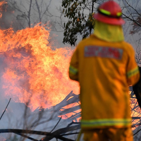 A firefighter defends a property in Torrington, near Glen Innes, 