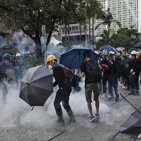 Protesters take cover as police and security forces fire tear gas during clashes in Hong Kong. 
