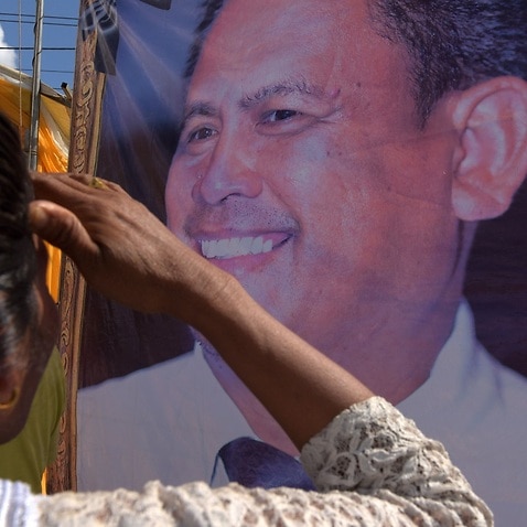 A Cambodian woman looks at a portrait of prominent Cambodian critic Kem ley during the first anniversary of his murder