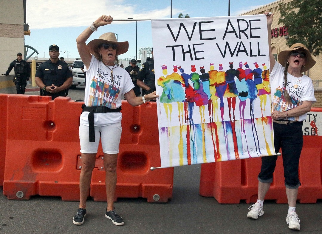 US Border Protection officers watch on as demonstrators criticism immigration routine outward a Paso Del Norte International Port of Entry in downtown El Paso. 