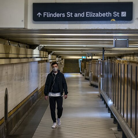 A lone person is seen walking under Flinders Street Station in Melbourne.