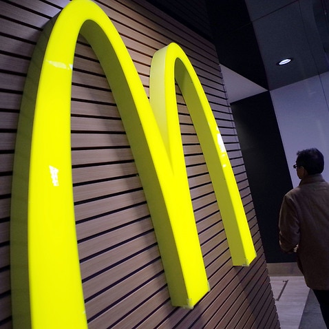 FILE - In this Dec. 17, 2014 file photo, a man walks by a McDonald's logo in front of its restaurant in Tokyo. McDonalds is set to unveil its latest plans to revive its sputtering business on Monday, May 4, 2015. (AP Photo/Eugene Hoshiko, File)
