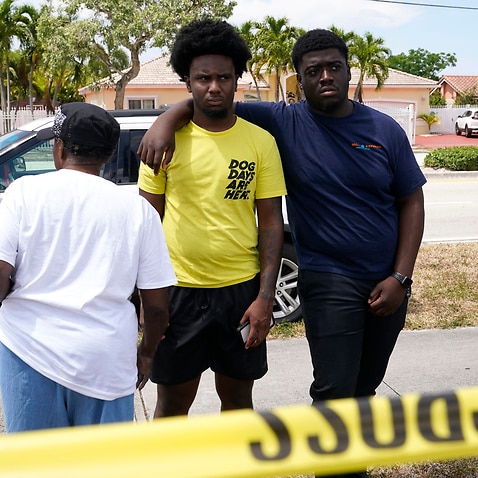 People wait for information at the scene of a fatal shooting at a banquet hall near Hialeah, Florida., Sunday, 30 May, 2021. 