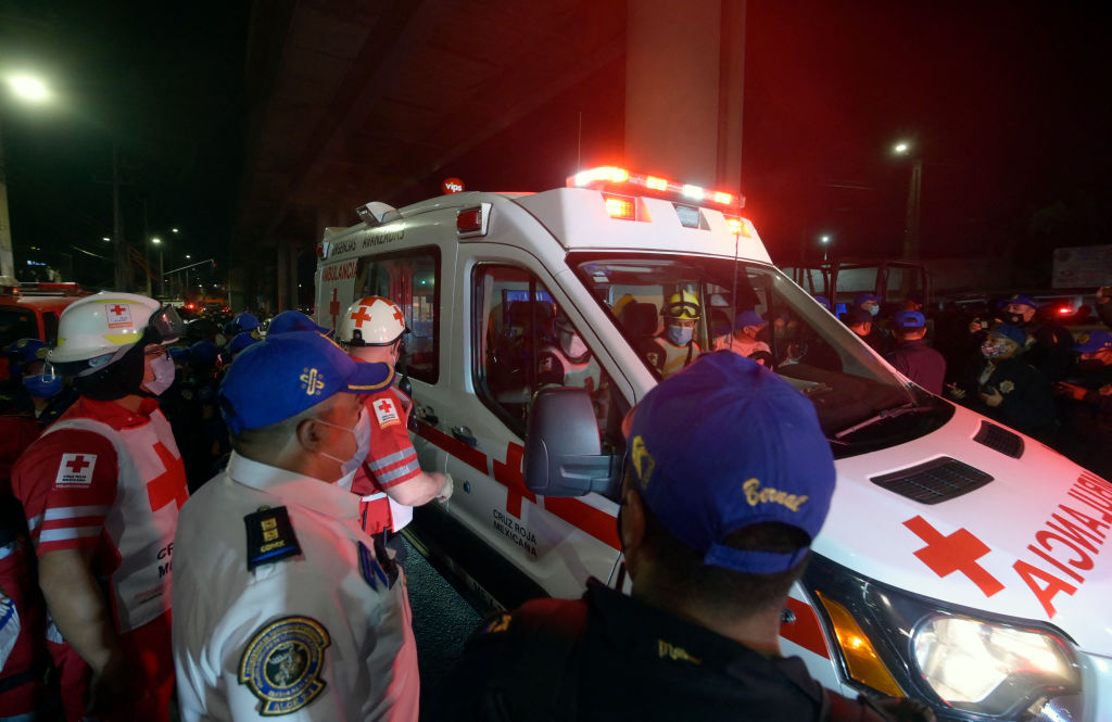 Members of the Mexican Red Cross work at the scene of an accident after an overpass for a metro partially collapsed in Mexico City on 3 May, 2021. 