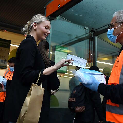NSW Transport workers hand out face masks at Town Hall rail station in Sydney, Thursday, May 6, 2021. 