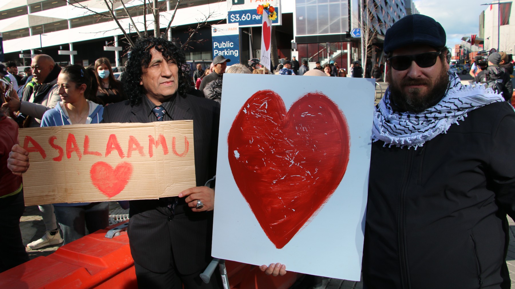 Taj Mohammad Kamran and Bader Dokhan outside the courts display writings with a big red heart drawing after the sentencing on the Christchurch Mosque attacker.