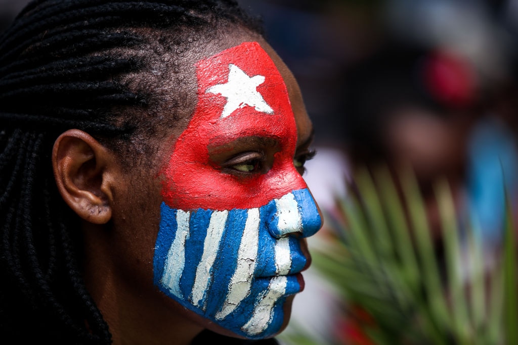 A Papuan student paints her face with the West Papua flag, the Morning Star during a rally in Jakarta, Indonesia, on 28 August, 2019.