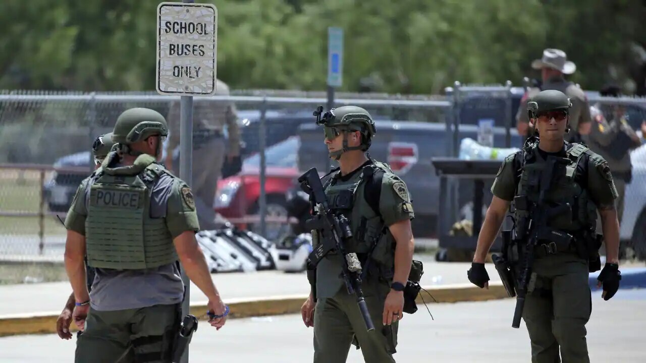 Law enforcement personnel stand outside Robb Elementary School in Uvalde, Texas following a shooting on 24 May 2022.