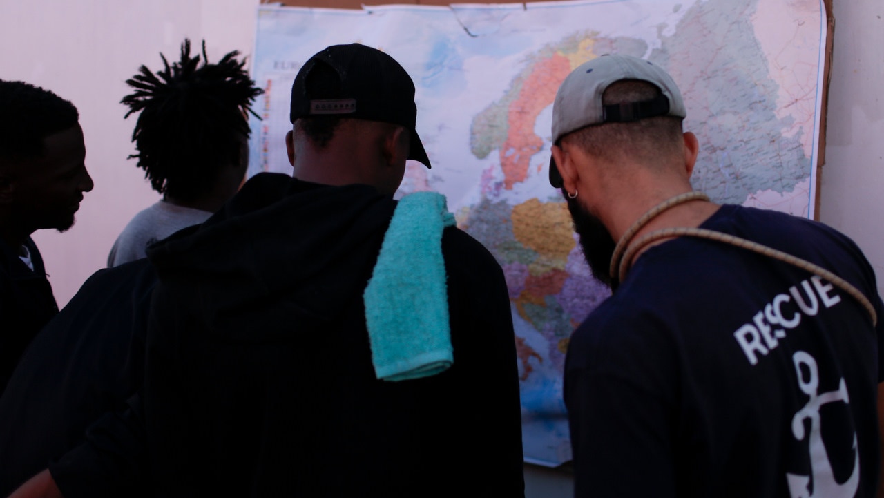 Men look at a map of Europe aboard the Ocean Viking in the Mediterranean Sea. Men look at a map of Europe aboard the Ocean Viking in the Mediterranean Sea.