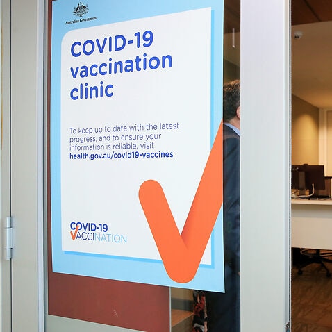 A COVID-19 Vaccination Clinic sign is seen as nurse Grace Gibney waits to receive one of the first Pfizer coronavirus vaccines at Austin Health in Melbourne