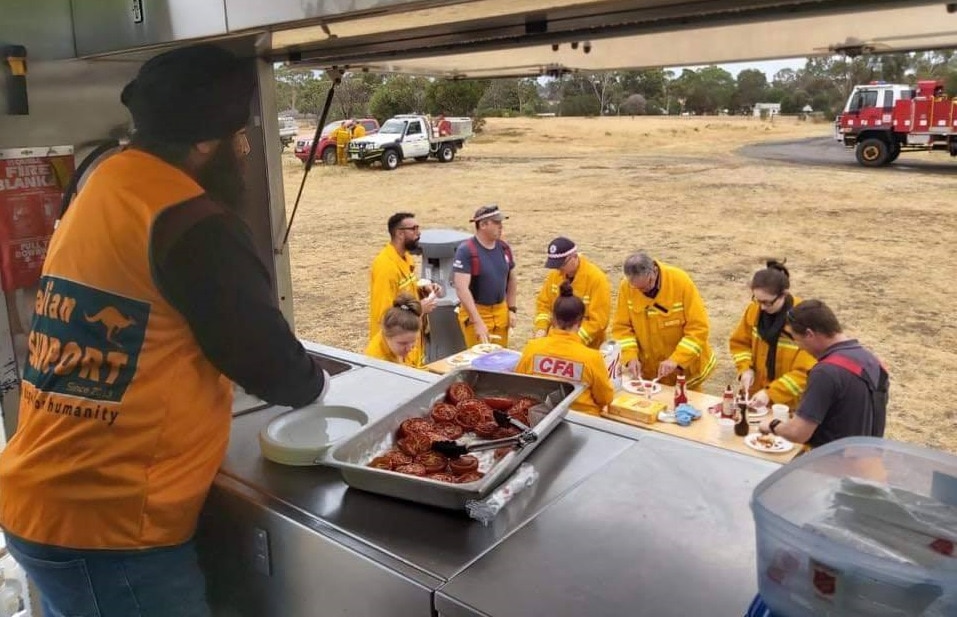 Sikh volunteers serving food to relief workers.  