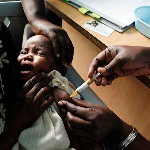 FILE - In this Oct. 30, 2009 file photo, a mother holds her baby as she receives a new malaria vaccine as part of a trial at the Walter Reed Project Research Center in Kombewa in Western Kenya. The World Health Organization says three African countries ha