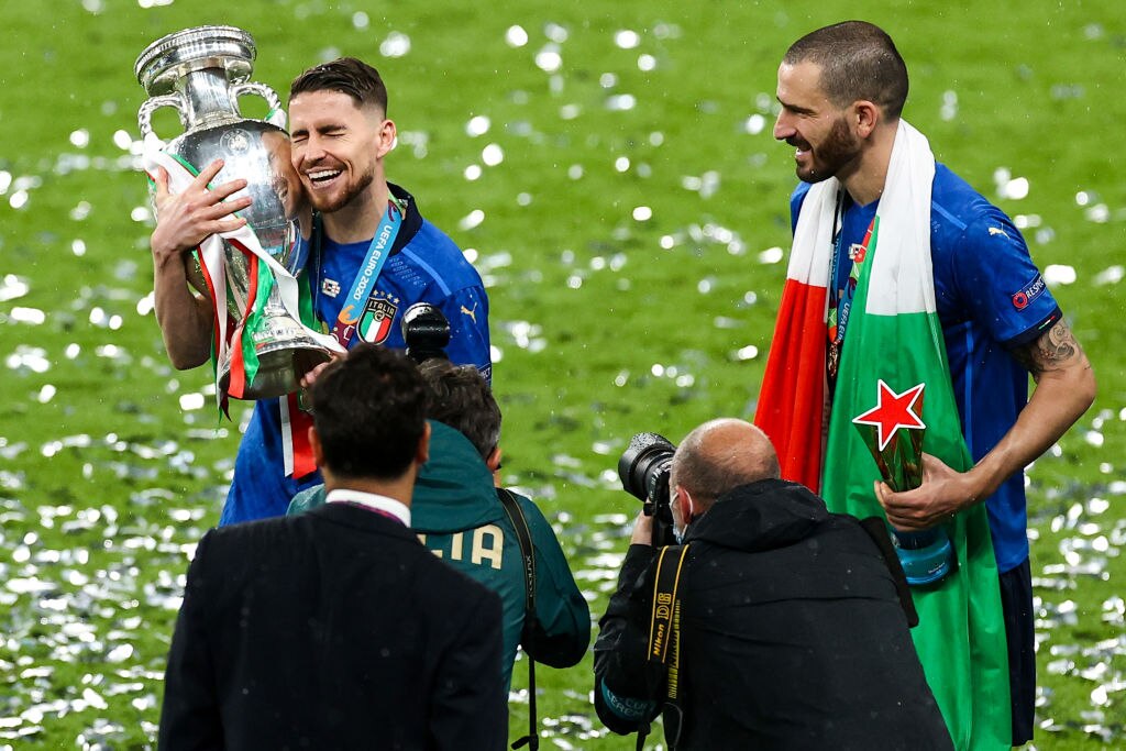 Italy's Jorginho (l) and Italy's Leonardo Bonucci celebrate with the trophy after the match. 