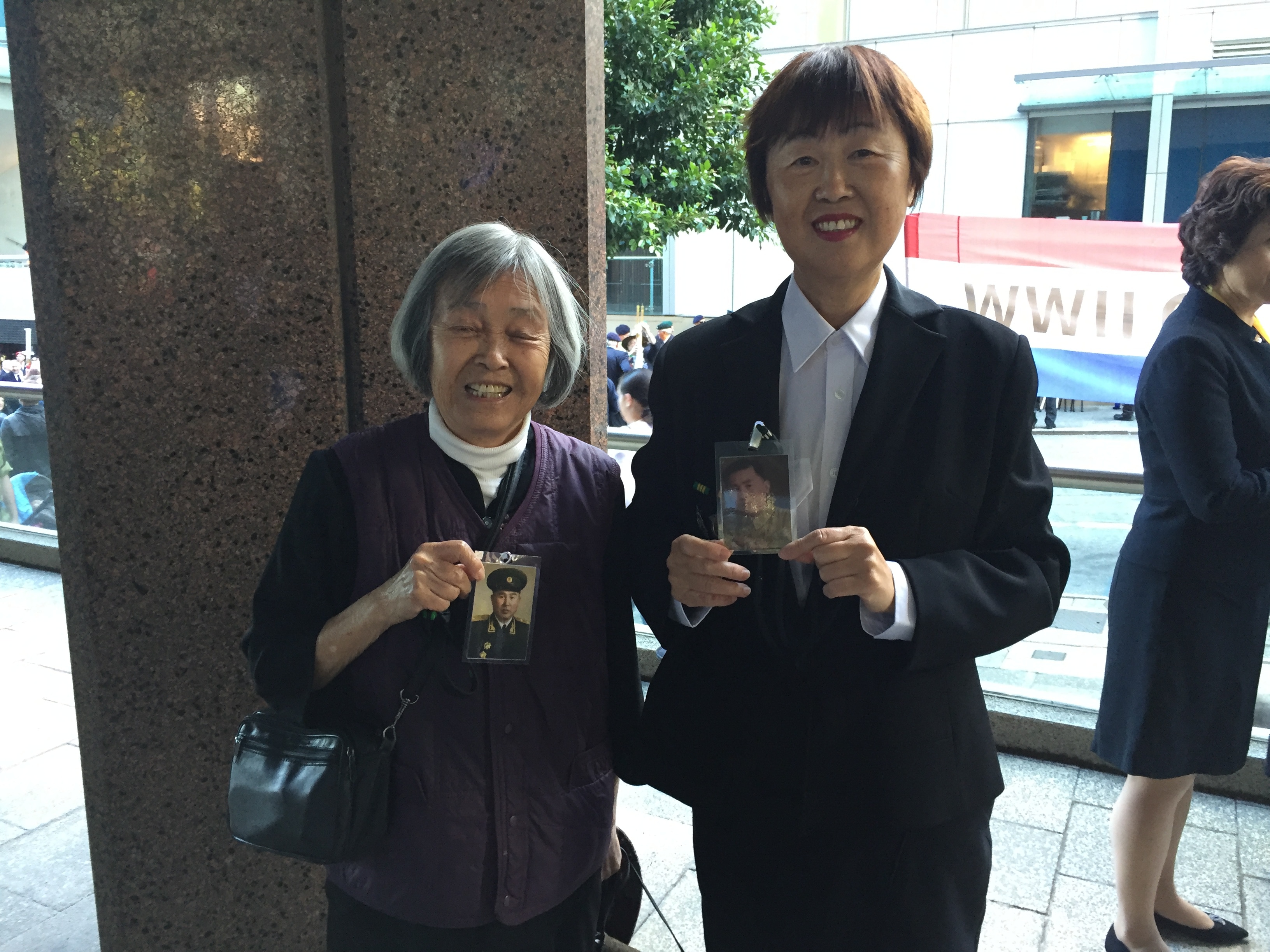 Mary (R) and her mother, Shu Qin Lu (L), with photos of her father Lie Yu.