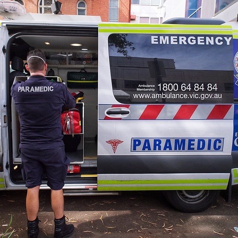 Paramedics are seen tending to their ambulance outside St Vincent hospital in Melbourne.