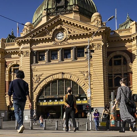 People walking across Flinders street station in Melbourne