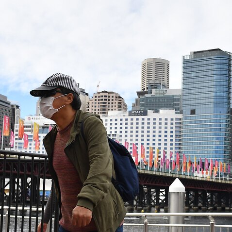A pedestrian is seen wearing a face mask at Darling Harbour in Sydney.