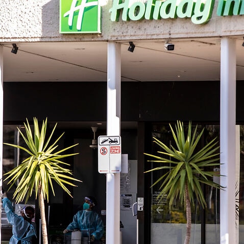 Cleaners are seen wearing full PPE while working at the Holiday Inn hotel on 10 February, 2021 in Melbourne, Australia.