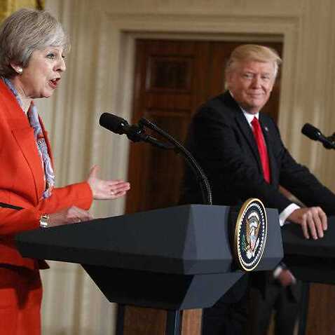President Donald Trump listens as British Prime Minister Theresa May speaks during a news conference in the East Room of the White House