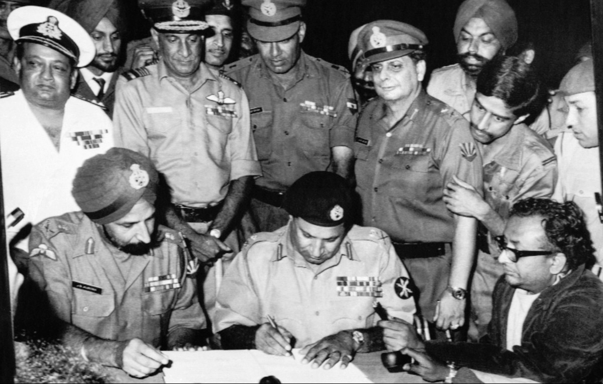 Pakistan’s Gen. Niazi, second from left, signs the surrender document as chief of India’s Eastern command Gen. Aurora, left, looks on surrounded by other commanders in Dacca, Bangladesh. 