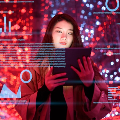 Young woman uses visual tablet at night 