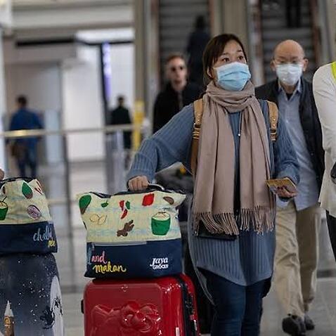 Travellers wear masks in the arrival hall of the Hong Kong International Airport this week