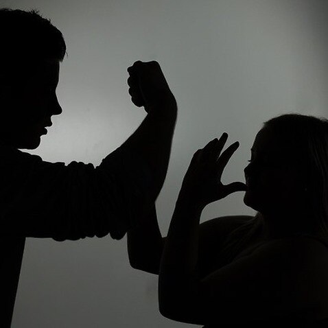The illustration shows the silhouette of a man threatening a woman