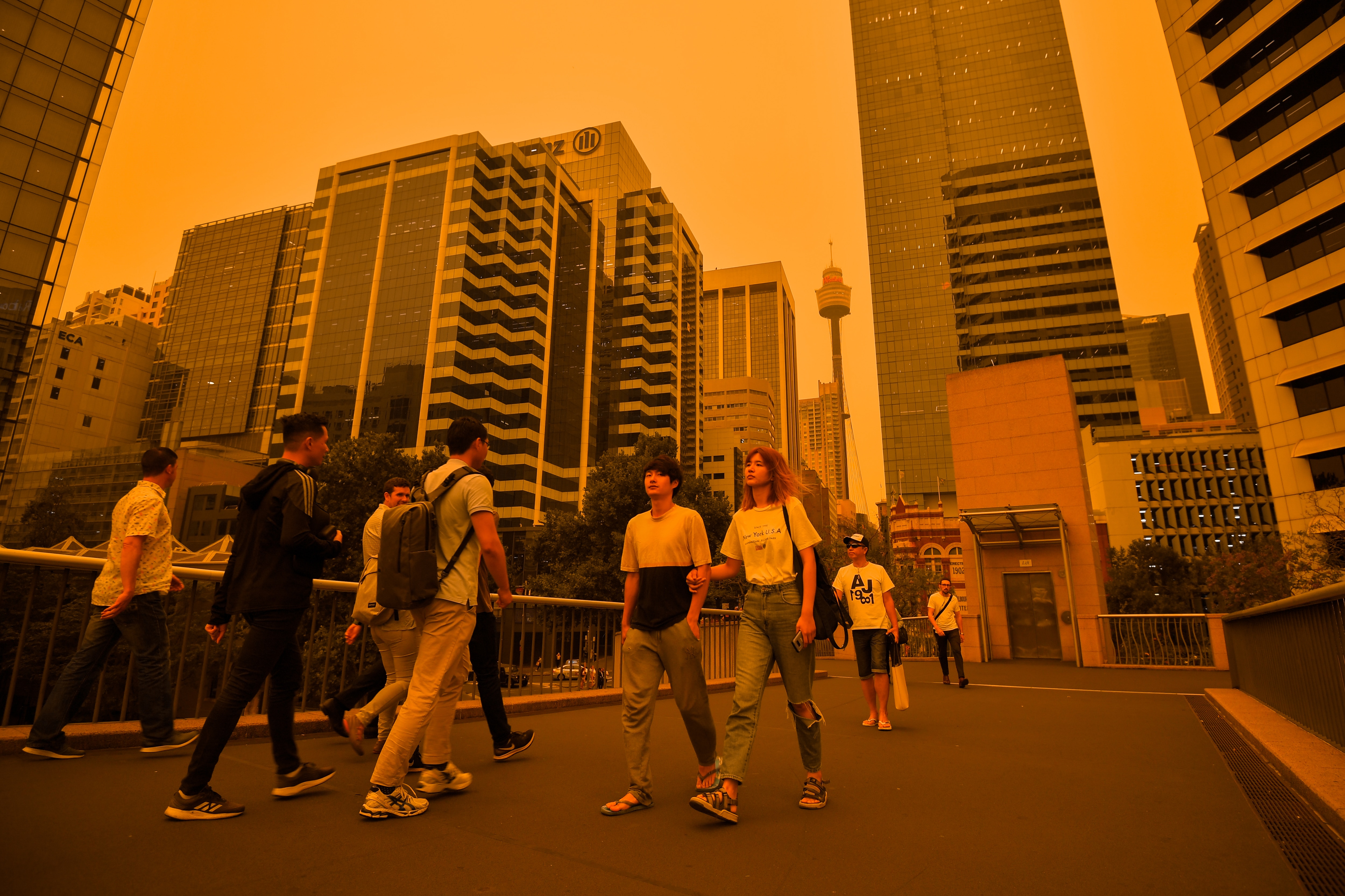 Pedestrians walk towards Darling Harbour as smoke haze blankets Sydney.