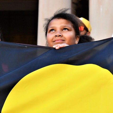 Children hold an indigenous flag at a Black Deaths in Custody Rally at Town Hall in Sydney, Saturday, April 10, 2021. 