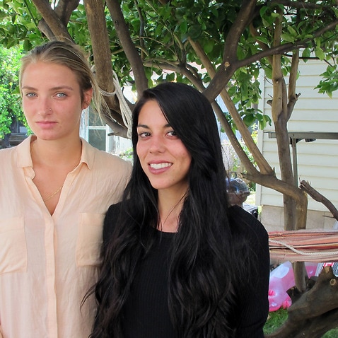 Courtney Wilson, left, and Taylor Guerrero posing for a photo in Honolulu.  Honolulu will pay $80,000 to settle the lesbian couple's lawsuit. (AP)