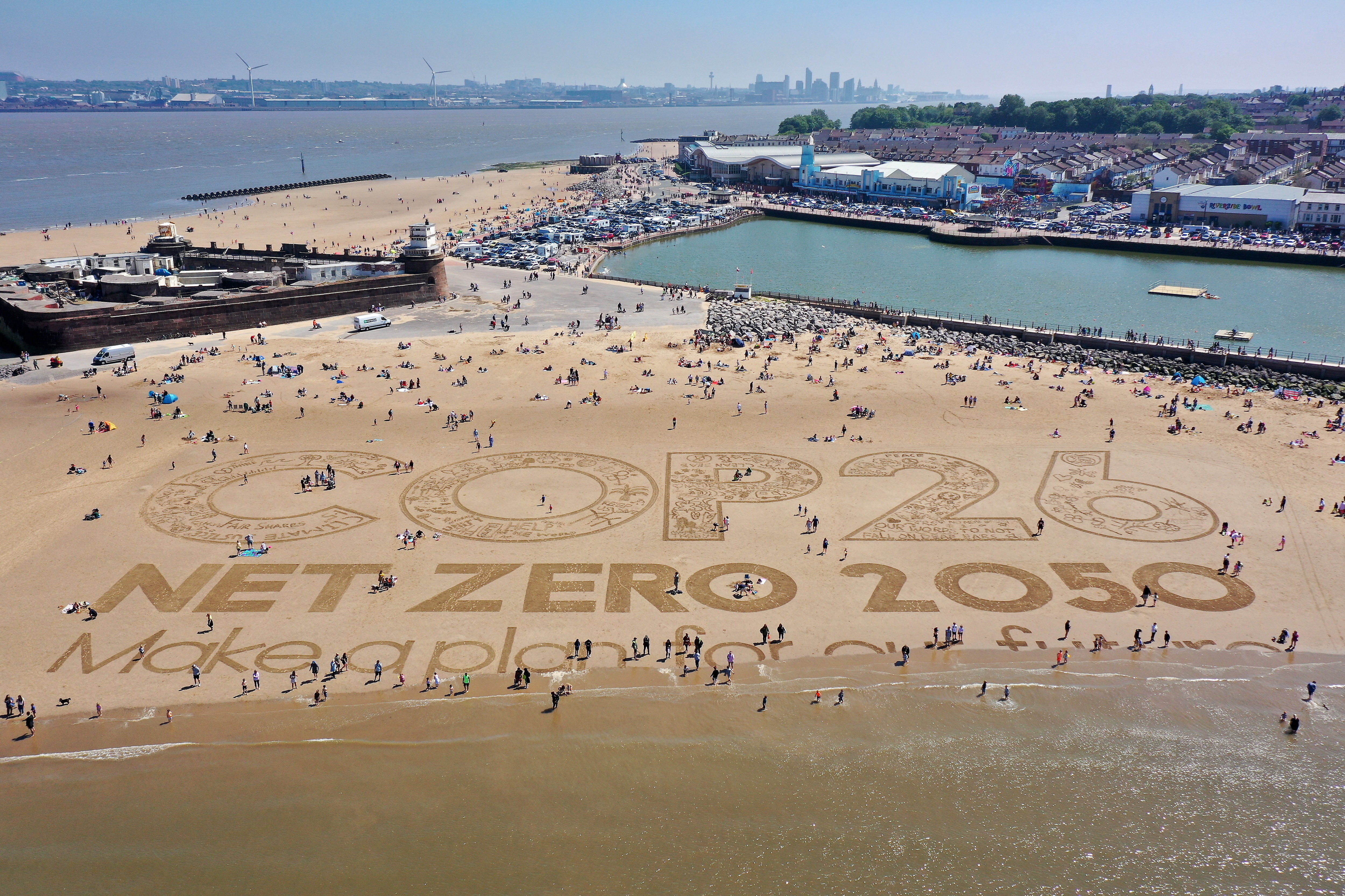 A giant sand art work adorns New Brighton Beach to to highlight global warming and the forthcoming COP26 global climate conference.