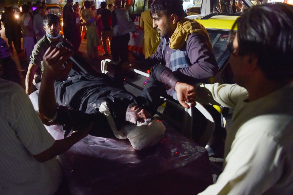 Kabul hospital staff bring in an injured man on a stretcher for treatment after the attacks