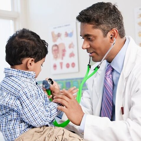 Doctor examining boy in doctor's office