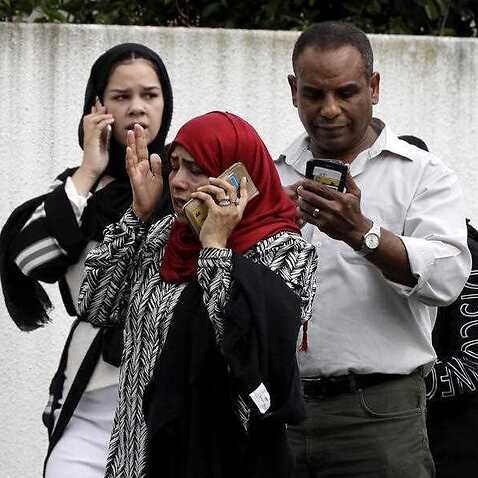 People wait outside a mosque in central Christchurch following the shooting.