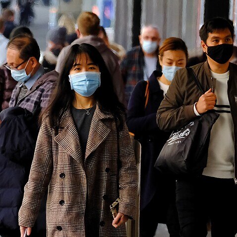 People wearing face masks walk in the Melbourne CBD, Thursday, July 15, 2021. Victoria has reported two new locally acquired COVID-19 cases, on top of the 10 reported in Thursday's official figures. (AAP Image/Luis Ascui) NO ARCHIVING