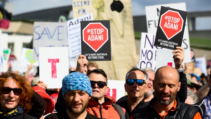 Protestors holding signage during a Stop Adani rally outside Parliament House in Canberra, Sunday May 5.