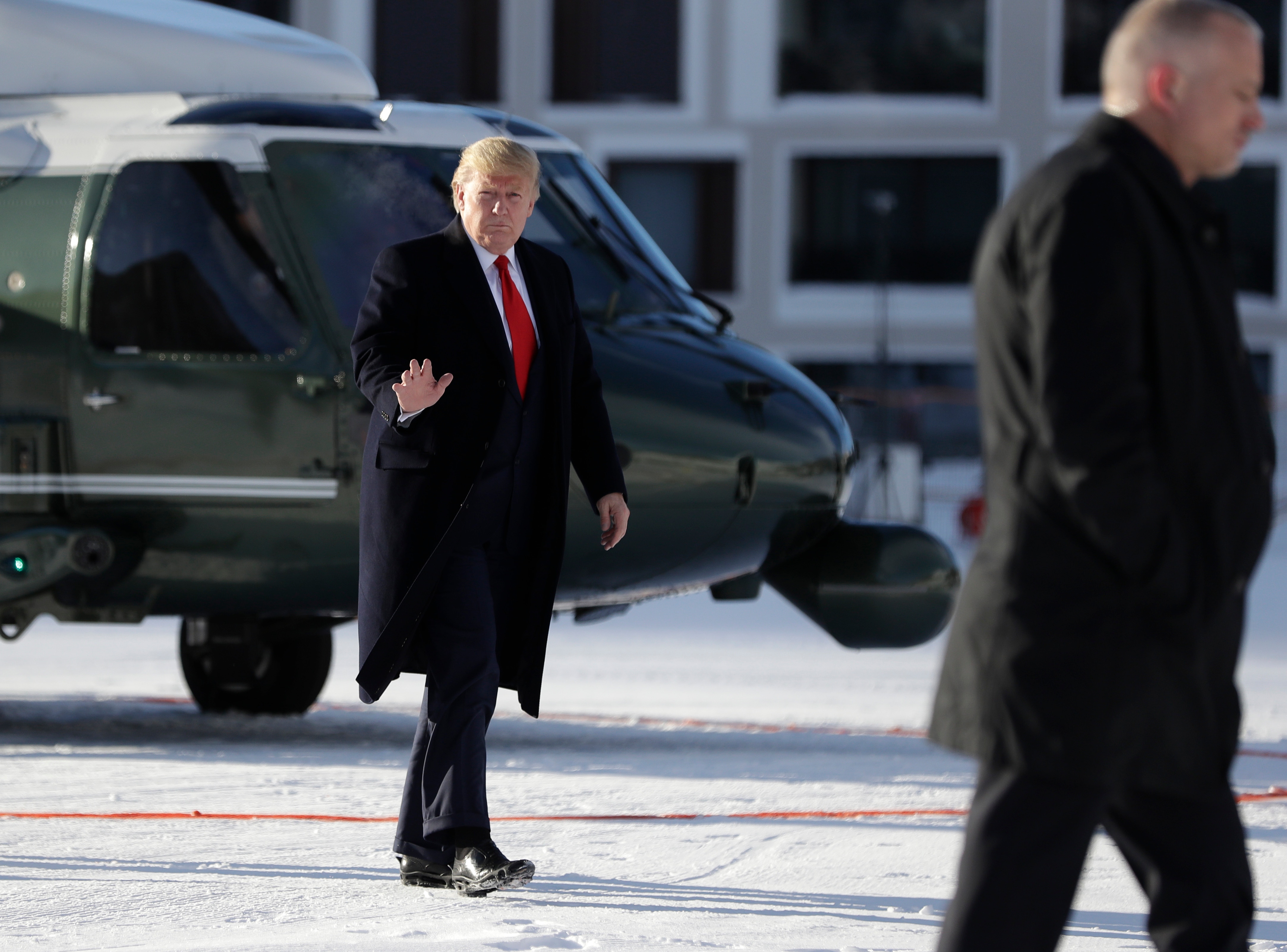 US President Donald Trump waves as he arrives in Davos