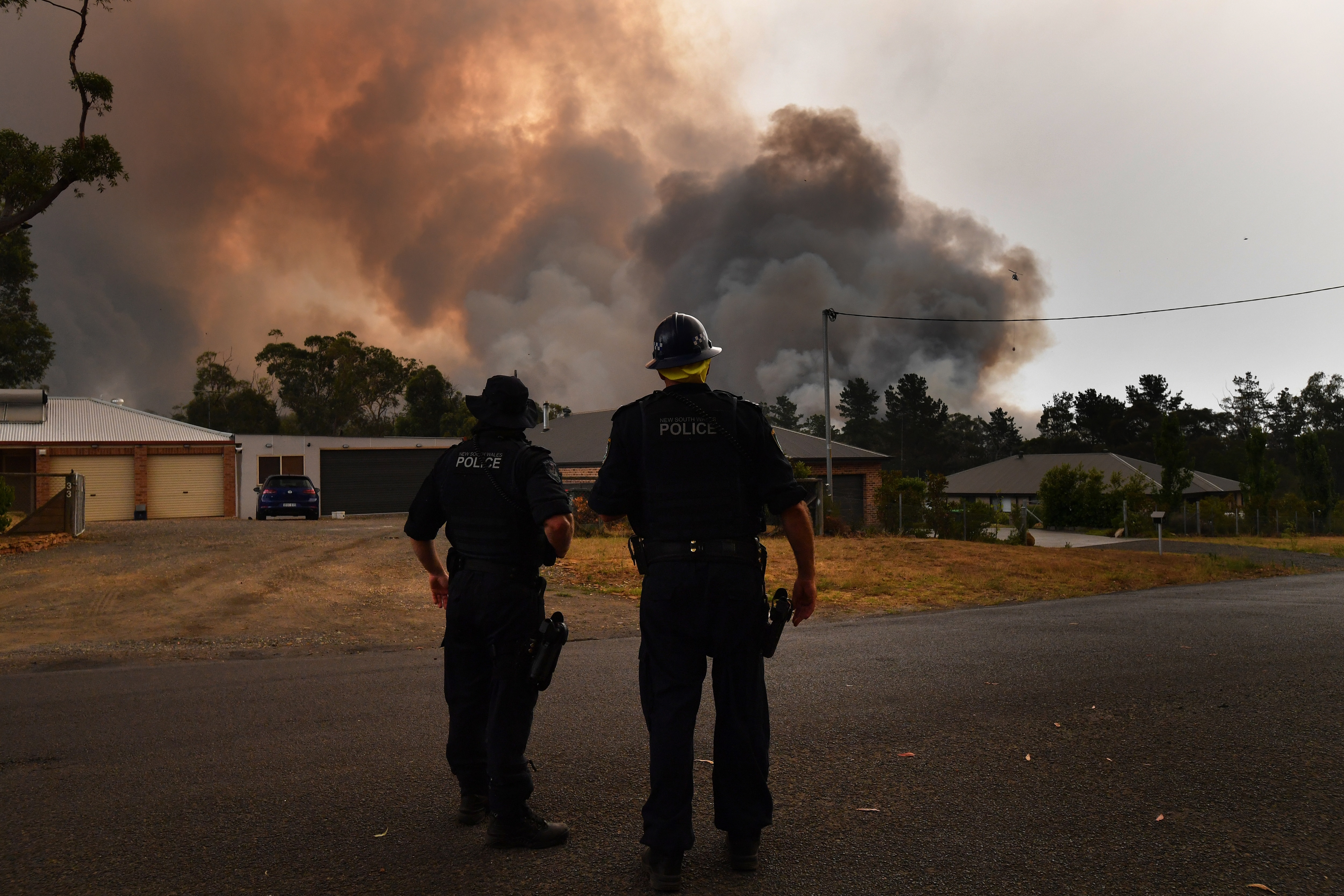 NSW Police watch as the Green Wattle Creek Fire threatens homes in Yandeera in the south west of Sydney.