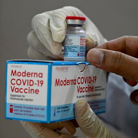 A health worker checks a box of the Moderna Covid-19 coronavirus vaccine donated by the US.