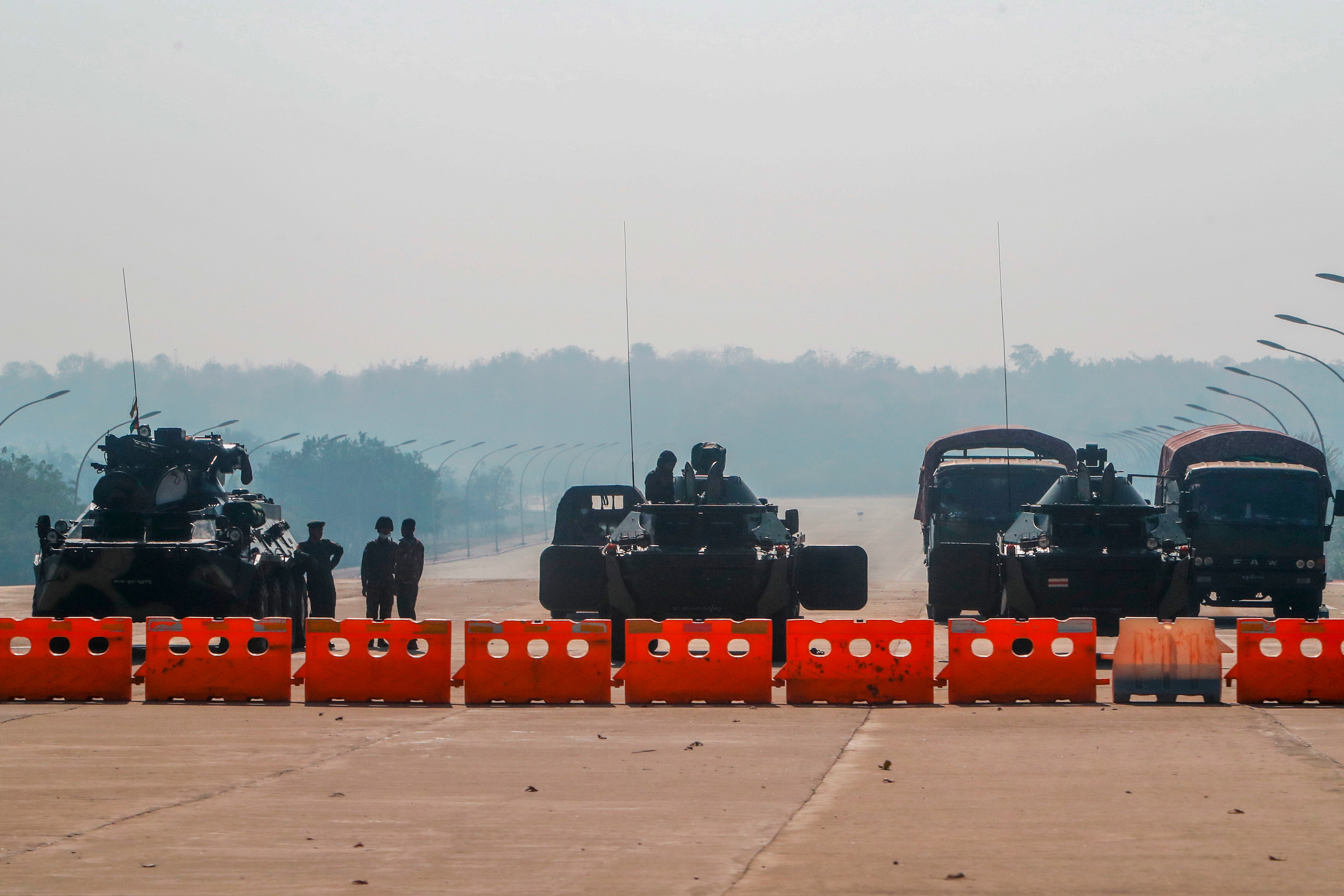 Myanmar's military stand guard at a checkpoint manned with an armored vehicles blocking a road leading to the parliament building on 2 February, 2021. 