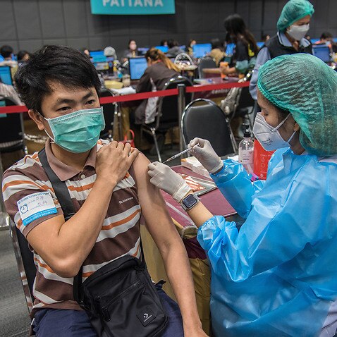 A health worker administers a dose of COVID-19 vaccine to a man in Nonthaburi.Thailand.