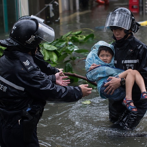 Police officers rescue a child from a flooded street during Typhoon Mangkhut in Lei Yu Mun, Hong Kong, China.