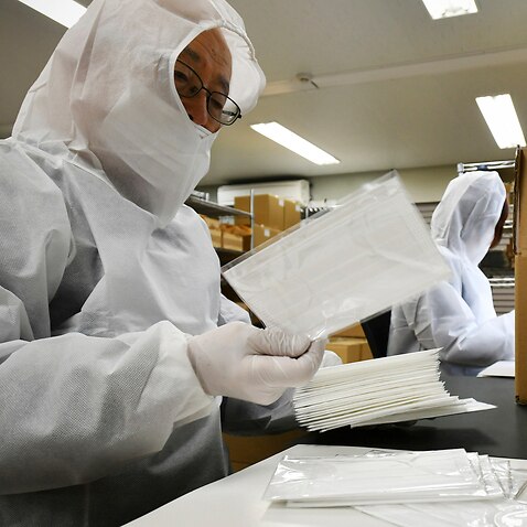 Employees from a mask company inspect products