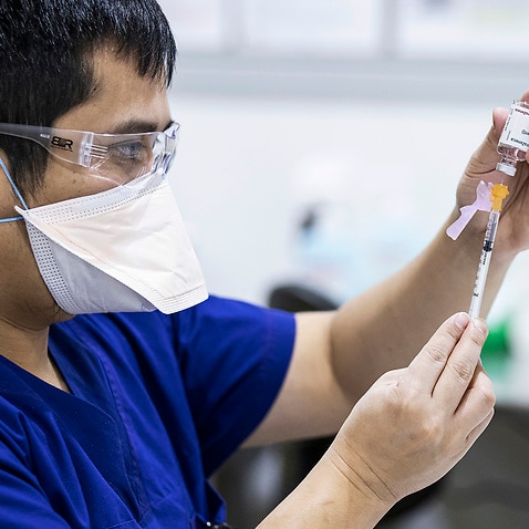 Staff are seen preparing AstraZeneca vaccine doses at a COVID-19 Vaccination Centre at Melbourne Showgrounds on 20 July, 2021.