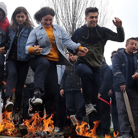 Teenagers jump over a bonfire during the Nowruz celebrations in Istanbul, Turkey.